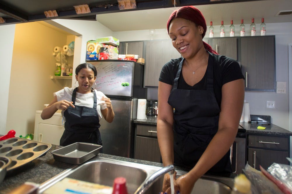 Interdiscplinary junior Kady Cox, right, and arts and humanities freshman Ciara Hamilton wash their hands before preparing food on Feb. 26, 2015 at 3850 East Coleman road in East Lansing. 