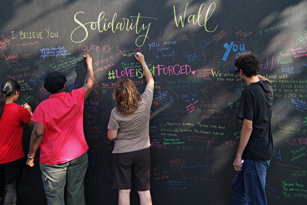 <p>MSU students write encouraging messages to survivors of sexual abuse on a "solidarity wall" set up by group Cravefest on Sept. 5, 2018.&nbsp;</p>