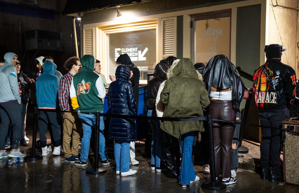 <p>MSU students wait outside in the rain to get into Lou &amp; Harry's Bar and Grill on Jan. 19, 2023.</p>