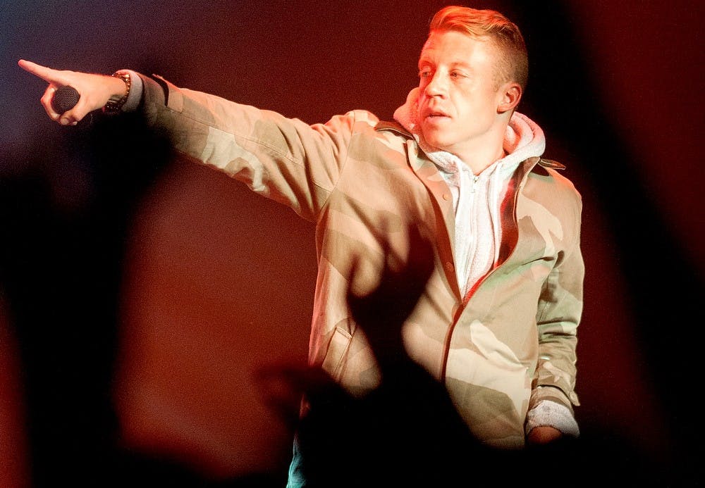 <p>Lead singer Macklemore points to DJ Ryan Lewis during a set on Tuesday, March 19, 2013. The Macklemore and Ryan Lewis concert was presented to students by ASMSU. Danyelle Morrow/The State News</p>