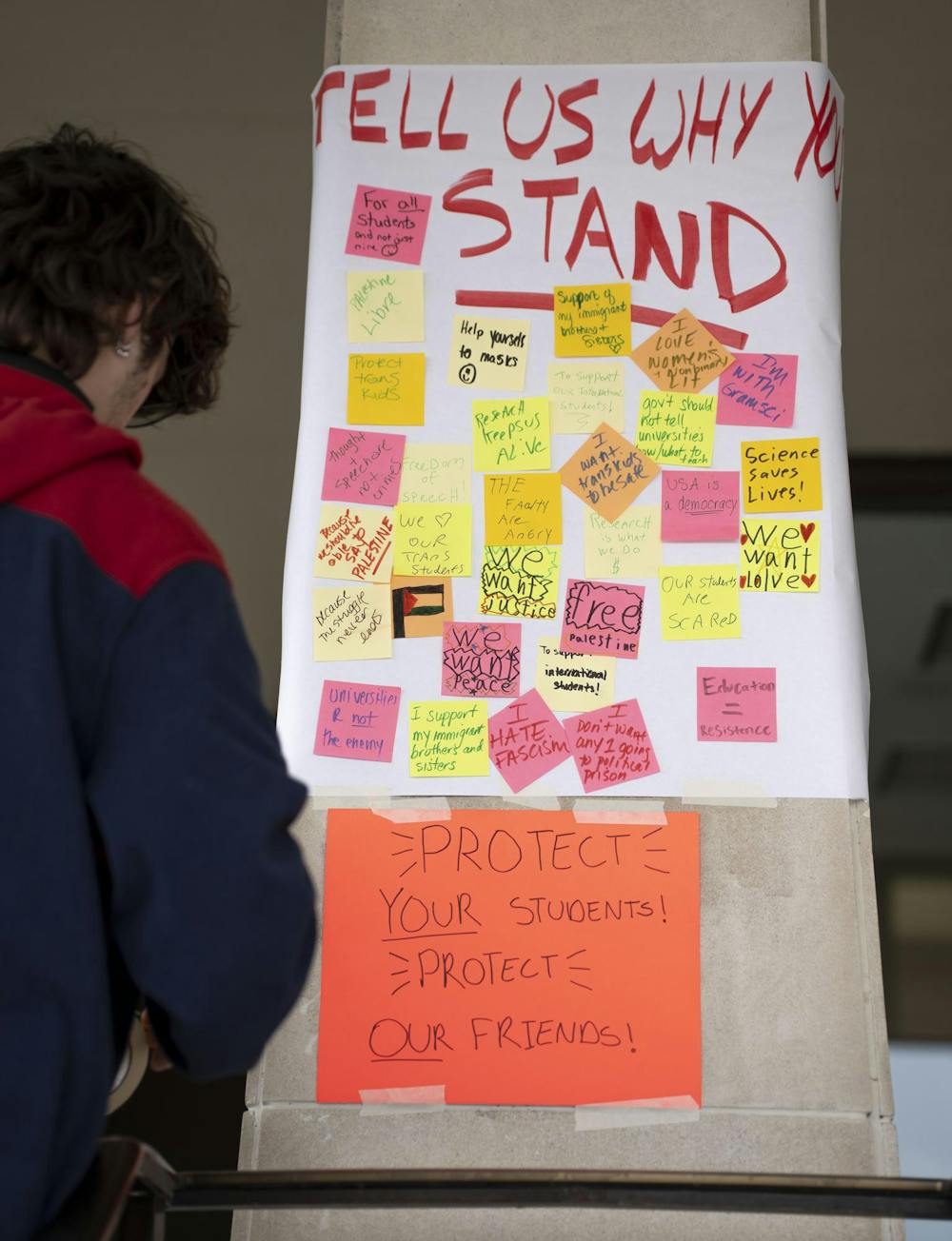 A poster titled “Tell Us Why You Stand” covered in handwritten notes during the Stand Up for Higher Education Rally outside the Hannah Administration Building on April 17, 2025.