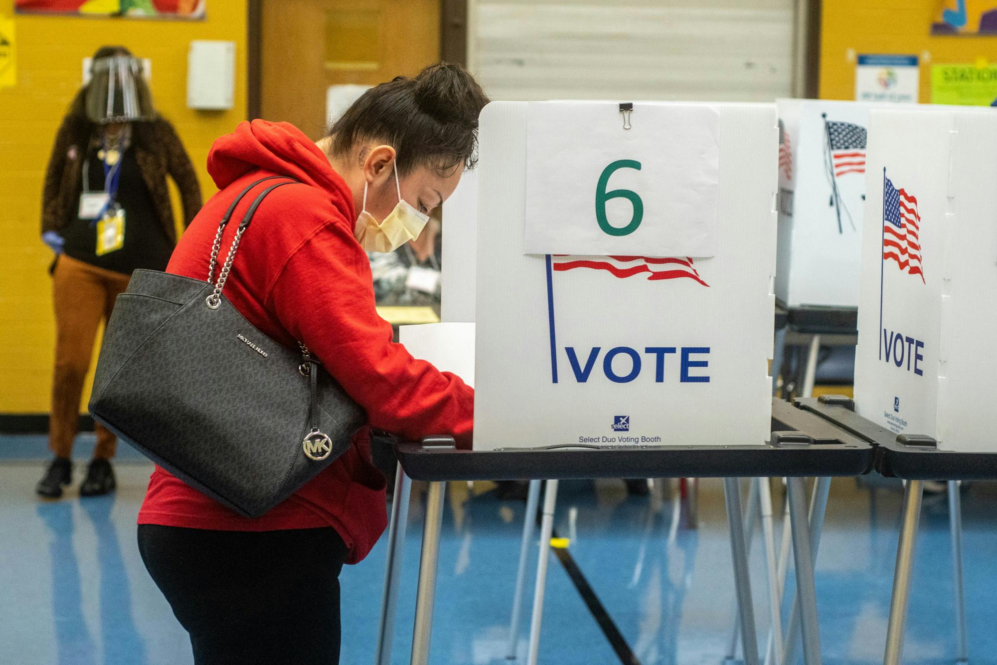 <p>A voter fills out their ballot at Willow Elementary School in Lansing on Nov. 3, 2020. This site houses two precincts and had people trickling in for both precincts.</p>