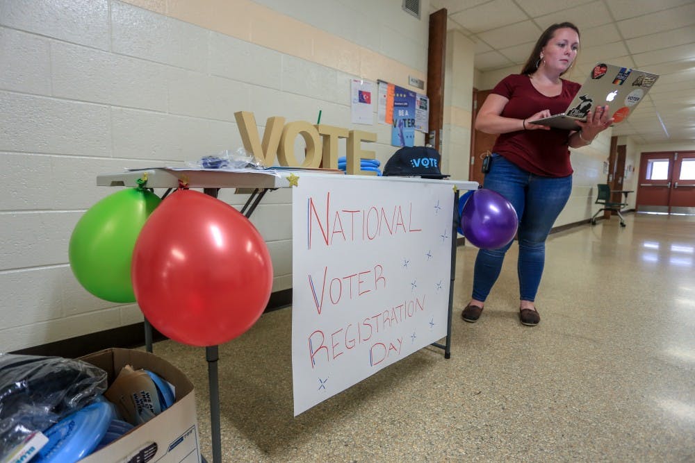 Regional Organizing Director of Next Gen America Cayley Winters helps people register to vote at Wells Hall on Sept. 25, 2018.