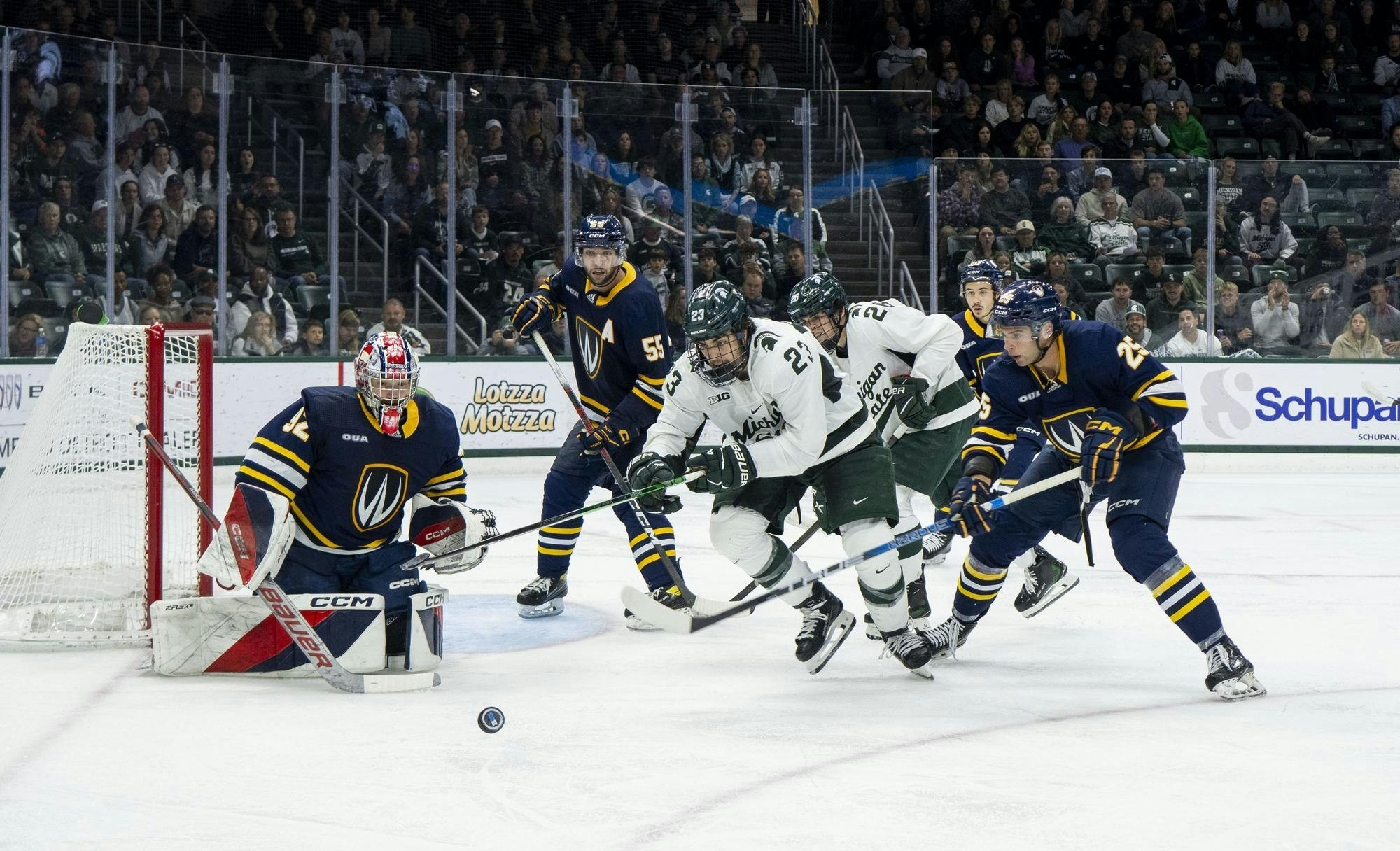 <p>Players on both teams run after the puck at the MSU vs. Windsor men's hockey game at Munn Ice Area in East Lansing on Oct. 18, 2024.</p>