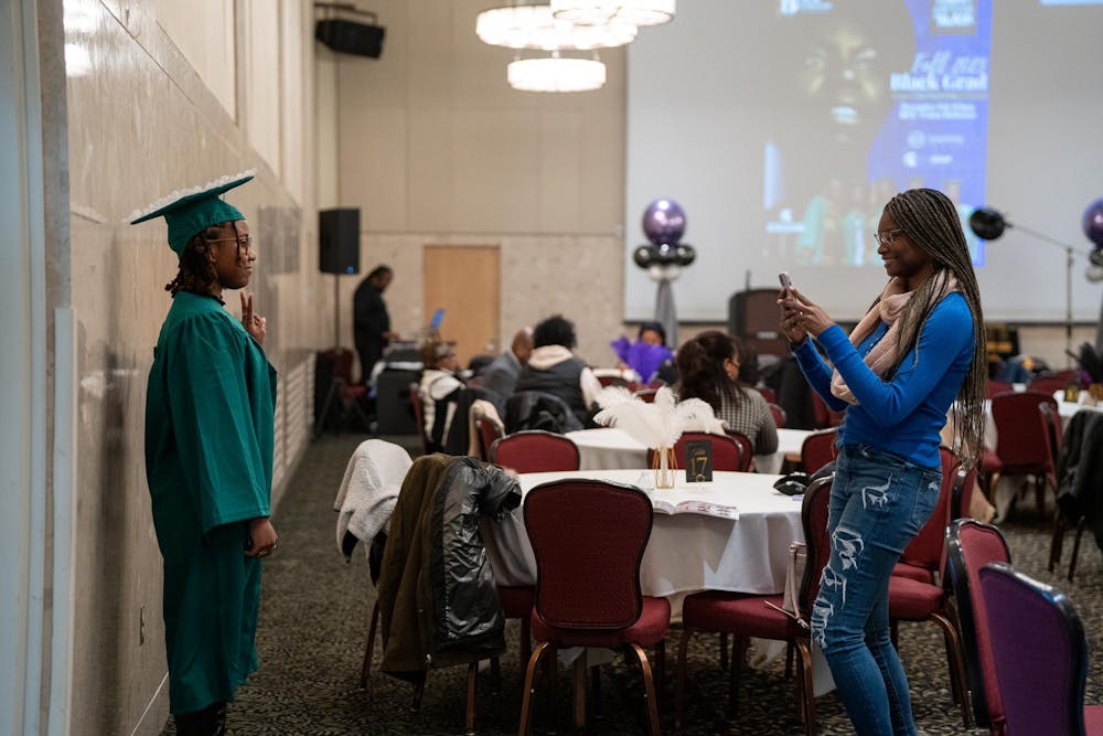 A family member takes a photo of an MSU Fall 2023 graduate before the Fall 2023 Black Grad event at the Union Ballroom on Dec. 8, 2023. 