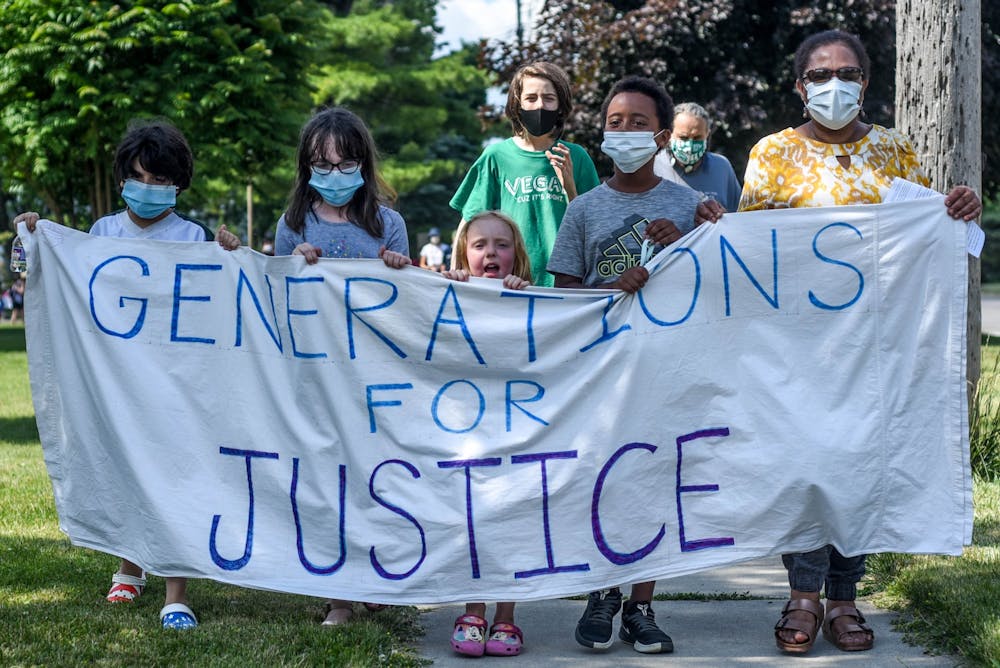 <p>People hold a sign at the Pinecrest Neighborhood Juneteenth march on June 19, 2020.</p>