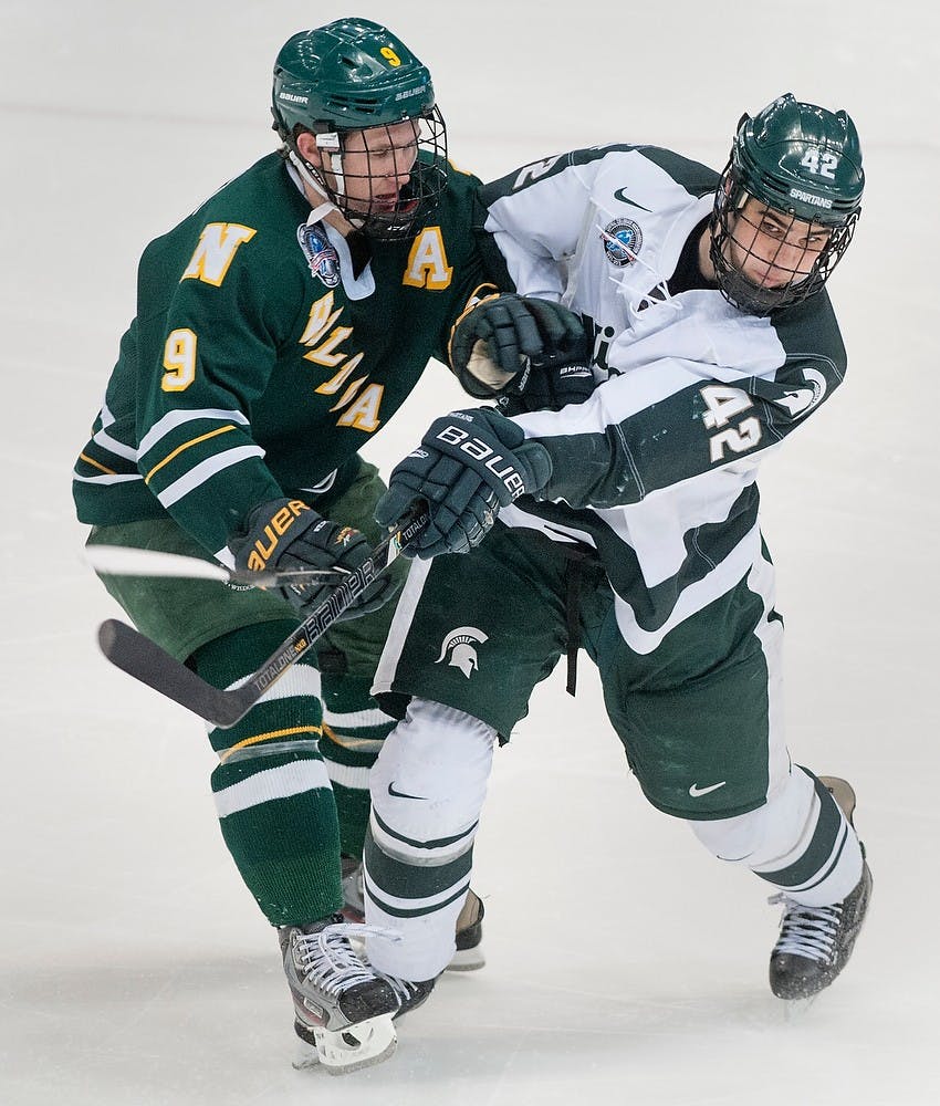 	<p>Junior defenseman Jake Chelios runs into Northern Michigan forward Reed Seckel after Chelios pushed the puck away. The Spartans defeated the Wildcats, 4-2, Saturday, Feb. 16, 2013, at Munn Ice Arena. Justin Wan/The State News</p>