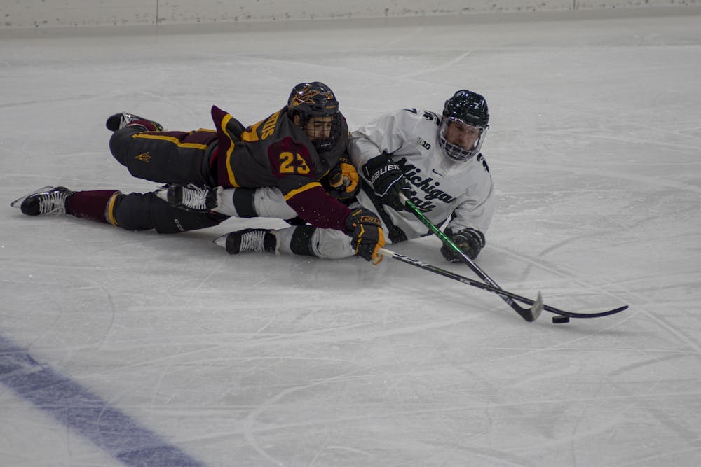 <p>Graduate student forward Charlie Combs (7) fights with Arizona State&#x27;s forward Demetrios Koumontzis for the puck during the third period. The Spartans tied 1-1 with the Sun Devils after four periods Nov. 19, 2020.</p>