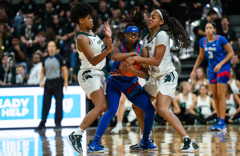 <p>Michigan State graduate student guard Nyla Hampton (22) and senior guard/forward Jocelyn Tate (11) attempt to steal possession of the ball from DePaul sophomore guard Shakara McCline (20) at the Breslin Center on Dec. 8, 2024. The Spartans won 89-61 against the Blue Demons, starting the season 9-0 for the first time in program history.</p>