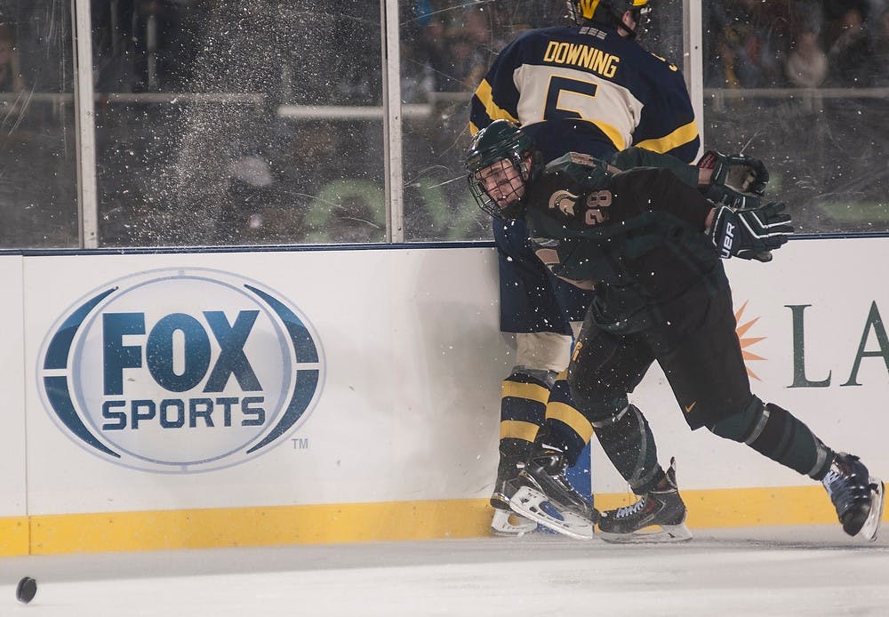 <p>Sophomore forward Thomas Ebbing fights past sophomore defenseman Michael Downing Feb. 7, 2015 during the Michigan State hockey game against Michigan at Soldier Field in Chicago, Illinois.  The Spartans were defeated by the Wolverines 4-1 during the Coyote Logistics Hockey City Classic. Alice Kole/The State News</p>