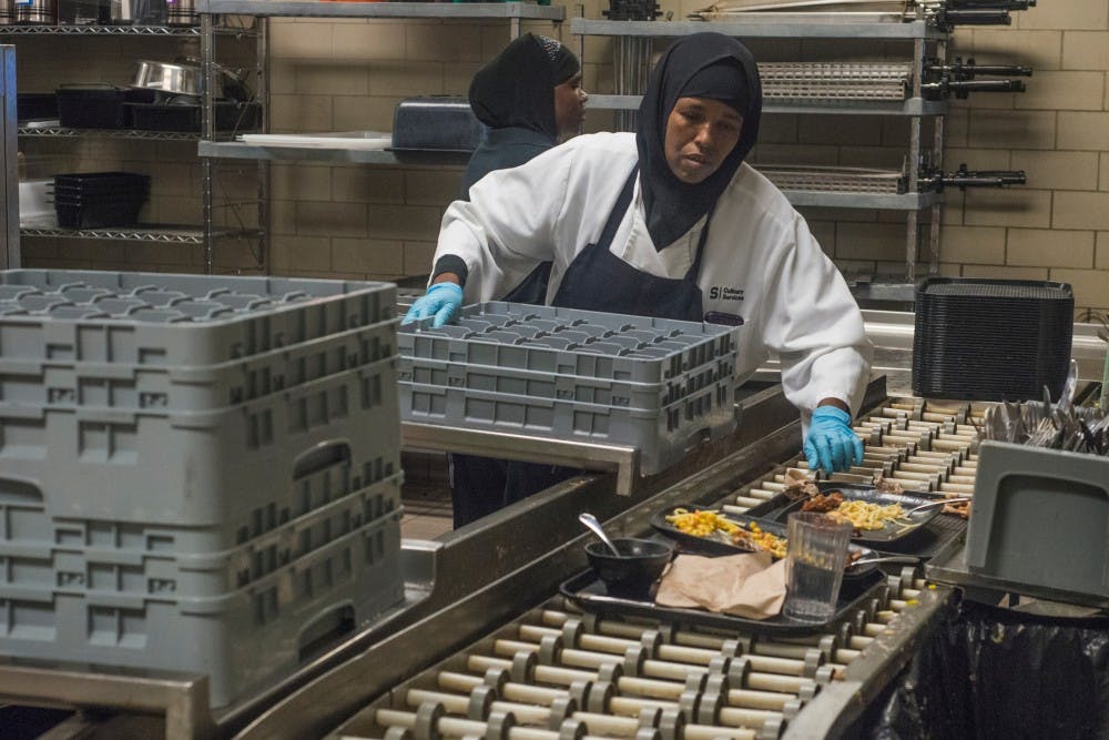 Dinning hall employees clear food off trays on Sept. 21, 2016 at Holden Hall. 