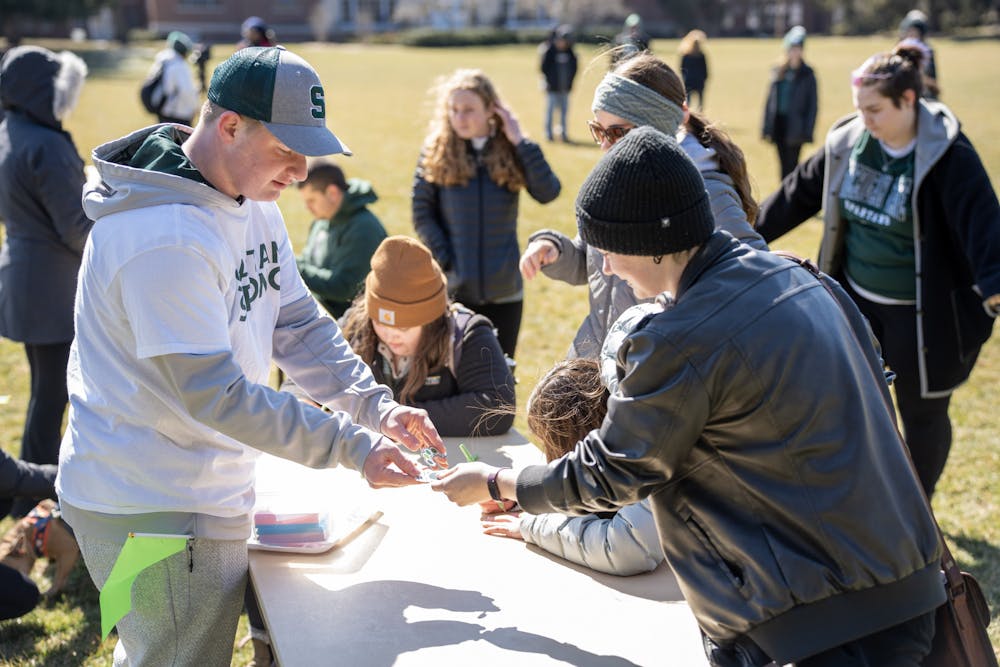 <p>Students fill out notecards at Demonstration Field, participating in the walkout on March 19, 2023.</p>