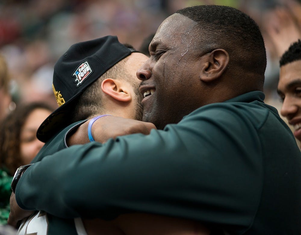 <p>Carlton Valentine embraces his son after the win March 28, 2015, during the East Regional round of the NCAA Tournament in the Elite Eight against Louisville at the Carrier Dome in Syracuse, New York. The Spartans defeated the Cardinals in overtime, 76-70. Erin Hampton/The State News</p>