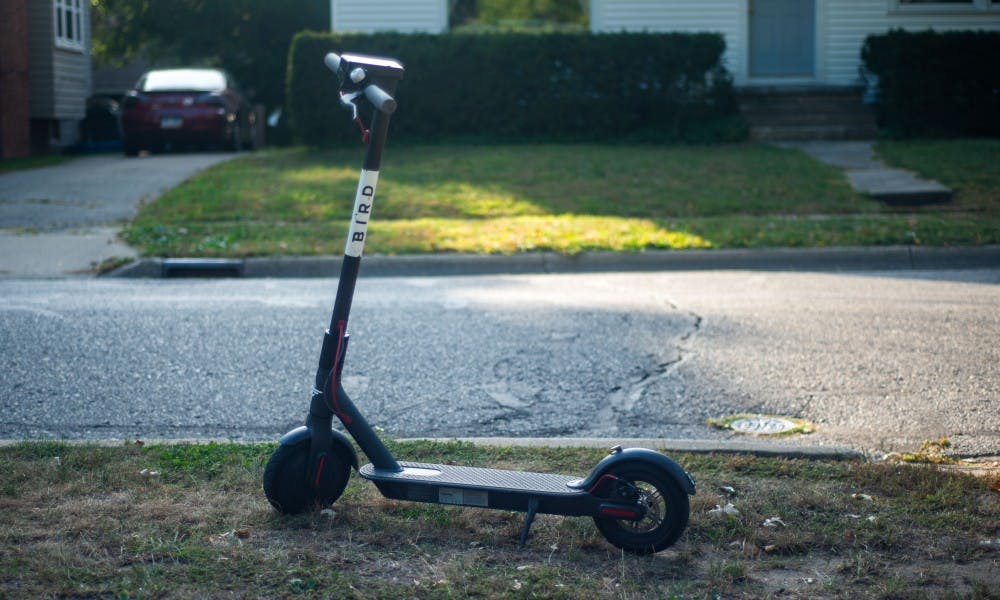A Bird scooter sits on the corner of Division St. and Sycamore Lane.