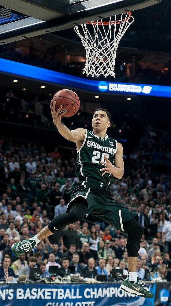 <p>Senior guard Travis Trice shoots Mar. 22, 2015, during the Round of 32 of the NCAA tournament in a game against Virginia at the Time Warner Cable Arena in Charlotte, NC. At halftime, the Spartans are leading the Cavaliers 23-18. Alice Kole/The State News</p>