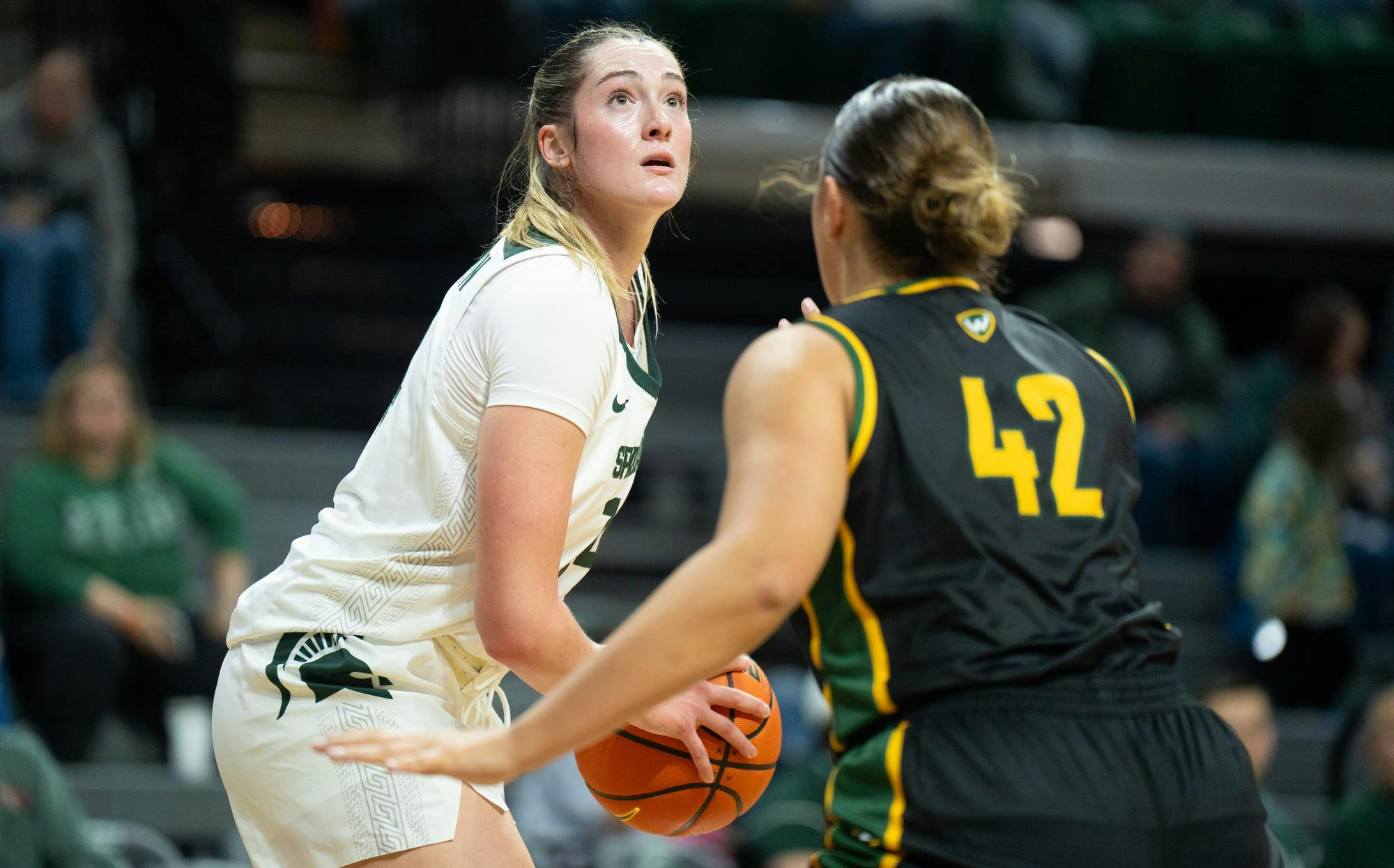 Michigan State University junior forward Grace VanSlooten looks to throw the ball while being guarded by Wayne State University junior forward Mackenzie Miller (42) in the Breslin Student Events Center on Oct. 28, 2024.