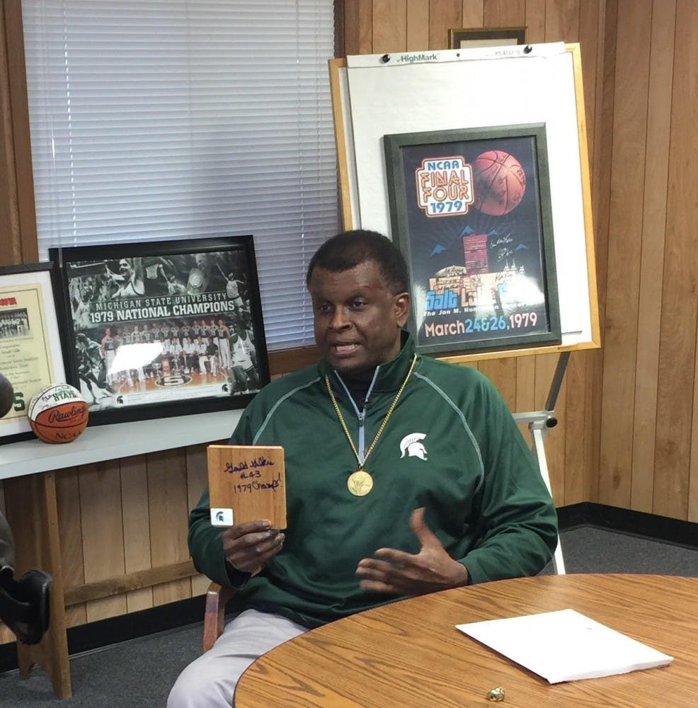 <p>Gerald Gilkie holds a piece of Jenison Field House's floor with his signature on it. Photo courtesy of Chris&nbsp;Gautz.</p>
