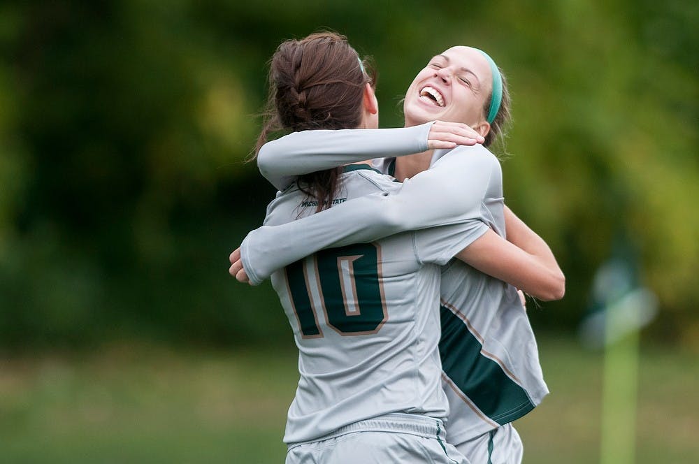 <p>Senior midfielder Megan Marsack, 10, hugs freshman forward Jamie Cheslik after Marsack's goal during the game against Nebraska on Oct. 5, 2014, at DeMartin Soccer Stadium at Old College Field. The Spartans defeated the Cornhuskers, 3-1. Jessalyn Tamez/The State News</p>