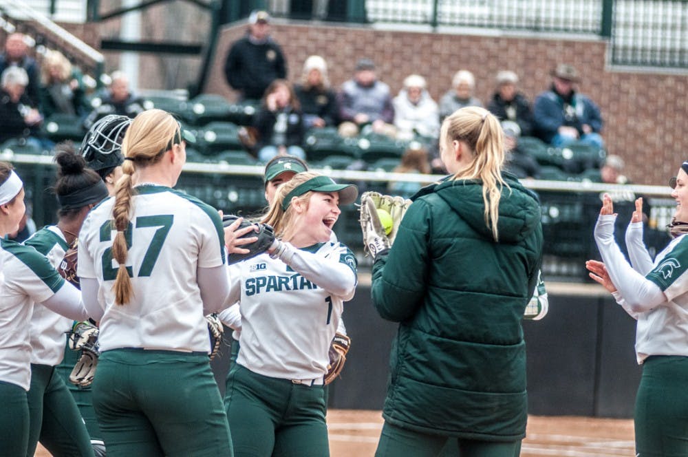 Senior outfielder Lea Foerster (1) high fives teammates before the home opener game against Western on March 28, 2018 at Secchia Stadium. The Spartans defeated the Broncos, 6-1.   
