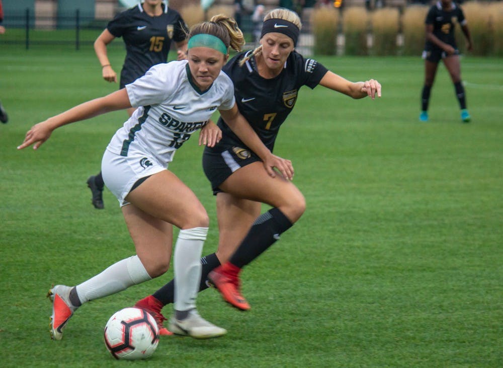 <p>Defender Athena Biondi (13) runs with Oakland’s midfielder Ali Amante (7) during the game against Oakland on Sept. 6, 2018 at DeMartin Stadium. The Spartans defeated the Grizzlies, 2-0.</p>