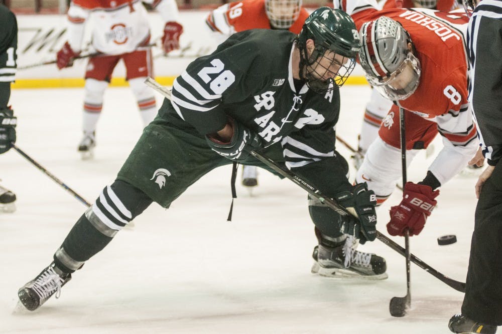 Senior center Thomas Ebbing (28) fights Ohio State center Dakota Joshua (8) for the puck during the first period of the men’s hockey game against Ohio State University on March 16, 2017 at Joe Louis Arena in Detroit. The spartans are up, 3-2. 