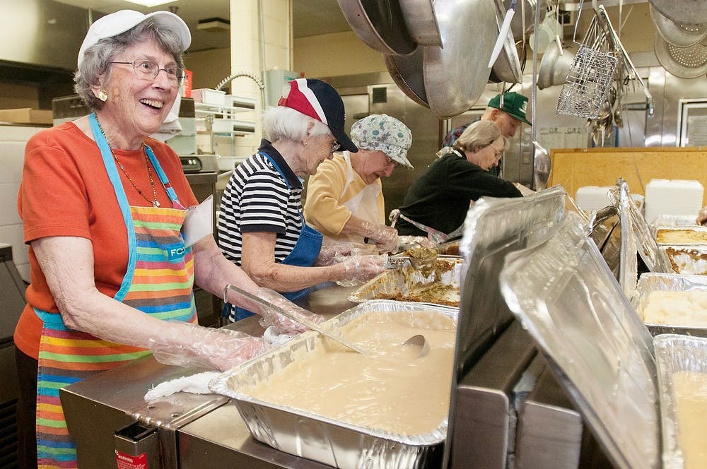 <p>Lansing resident Blanche Sahovetz smiles after pouring gravy on Thanksgiving dinners Nov. 19, 2012, at the Salvation Army. Julia Nagy/The State News</p>