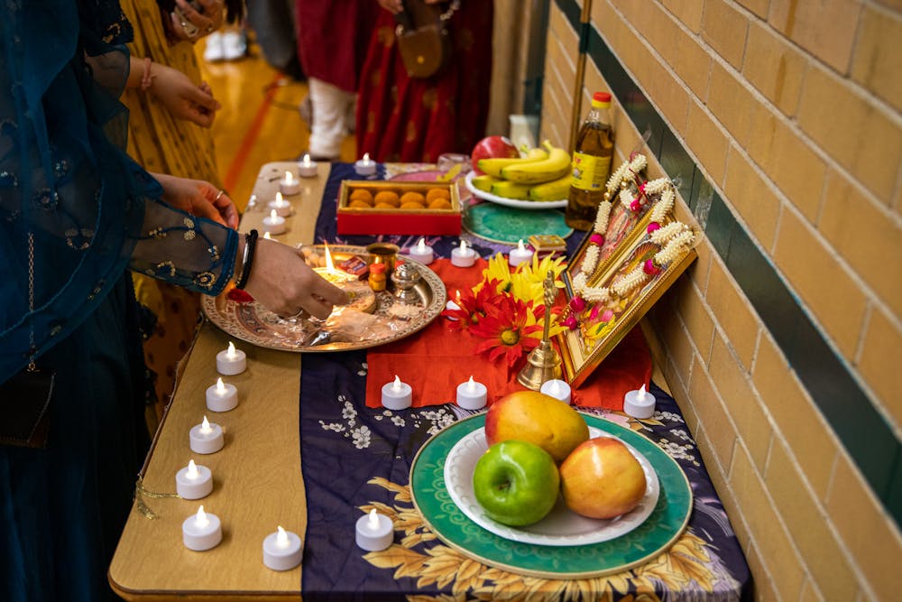 <p>A Diwali celebration was held at IM West Circle on MSU’s campus on Nov. 5, 2021. The event was put on by the Indian Student Organization at MSU in collaboration with the International Students’ Organization. Shown is a candle being lit during the pooja, a worship ritual performed by Hindus.</p>