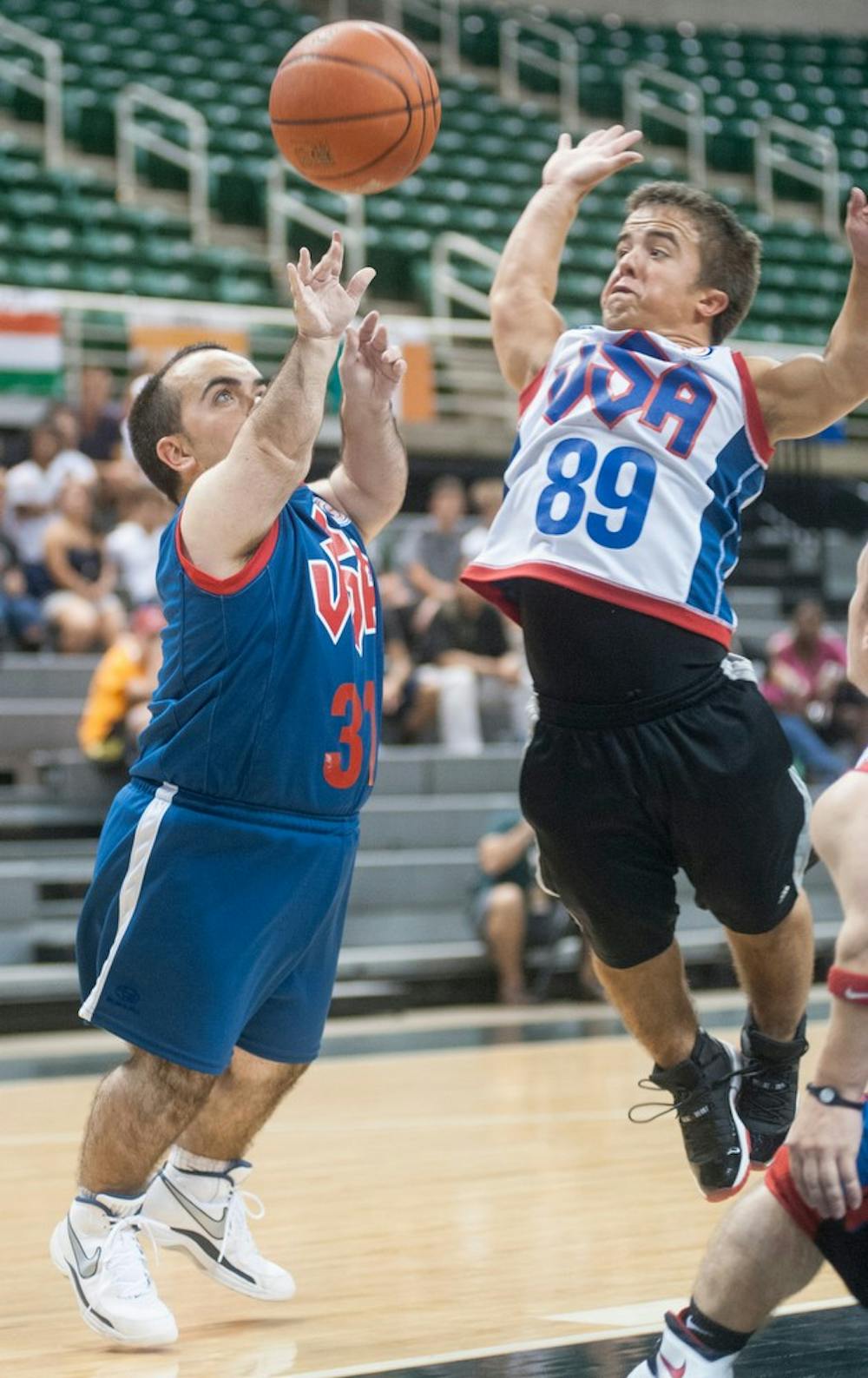 	<p>Daniel Fava, left tries to shoot as Adam Romano defends, Aug. 10, 2013, at Breslin Center during the basketball finals of the 2013 World Dwarf Games. The athletic competition ended with badminton and basketball finals. Justin Wan/The State News</p>