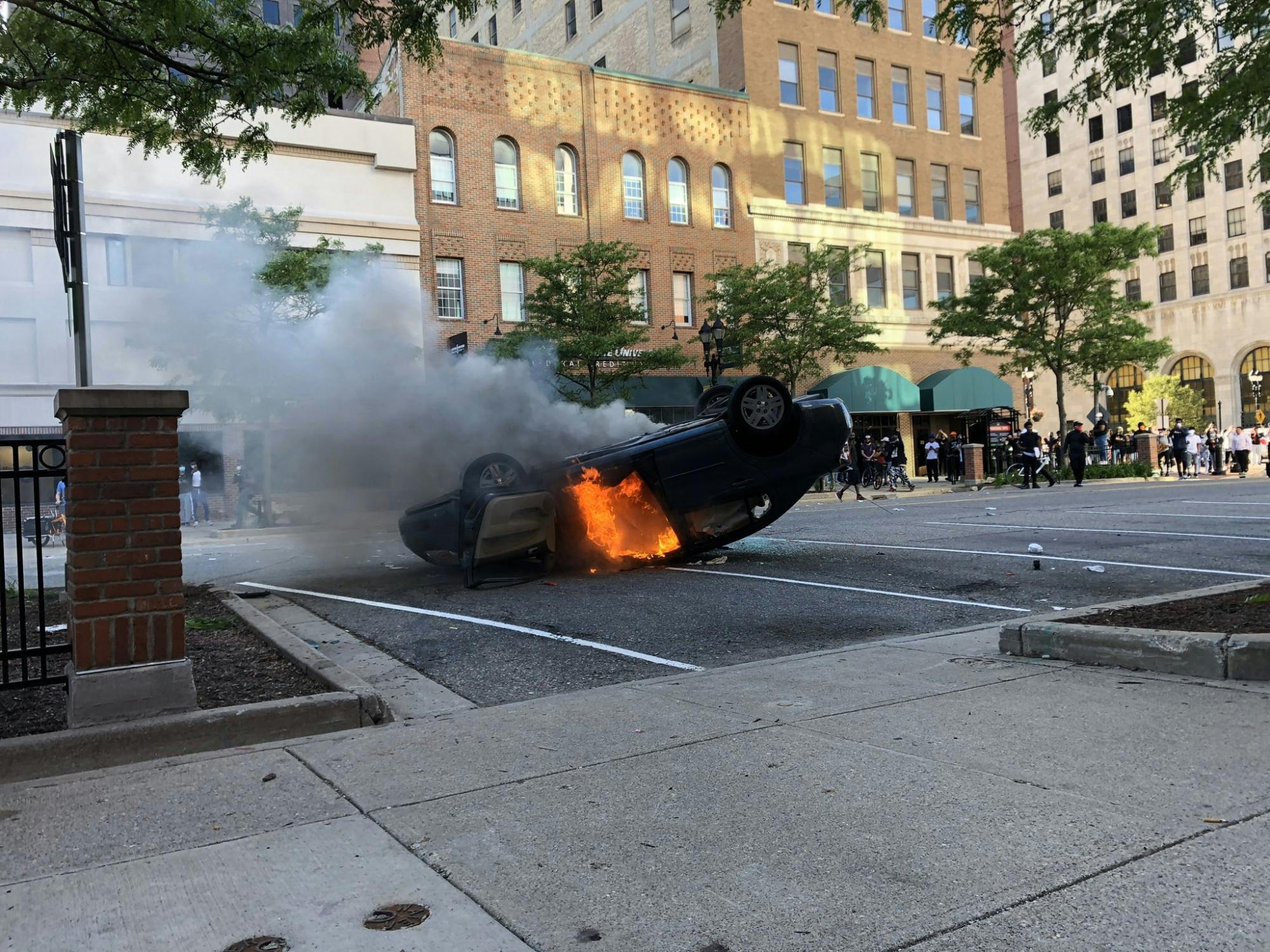 A car was set on fire during a protest in Lansing, Michigan. Prior, the owner of the vehicle was taken into custody after driving through a crowd of people. 