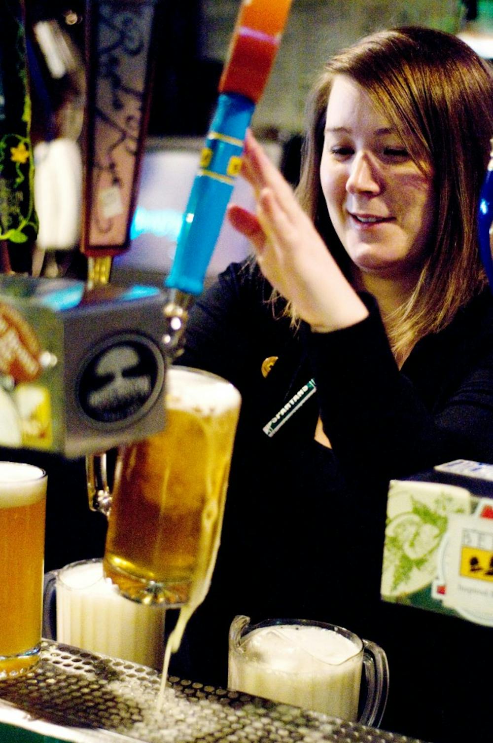 Crunchy's employee Kirby Metty fills a mug with Oberon Monday evening.