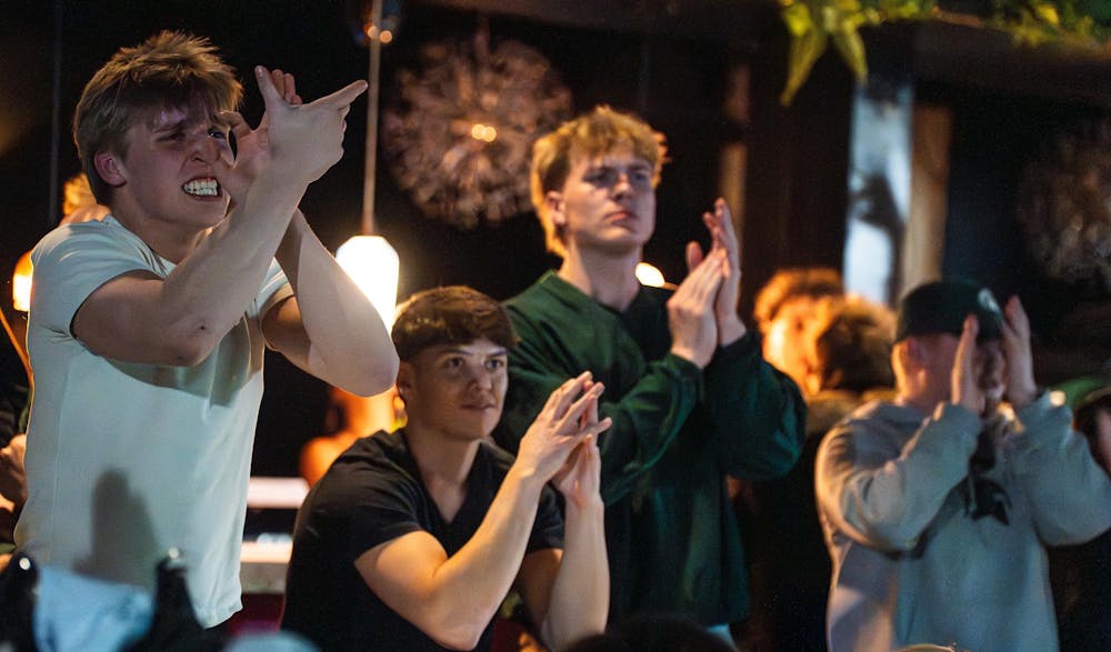 Fans react to an intense moment of the NCAA men’s basketball tournament regional semifinal game between Michigan State and UConn at Harper's Restaurant & Brew Pub in East Lansing, Michigan, Friday, March 27, 2026.