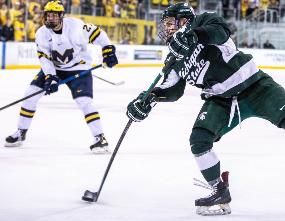 Senior defenseman Zach Osburn (2) shoots during the game against Michigan Feb. 9 at Yost Ice Arena. The Spartans fell to the Wolverines, 5-3.