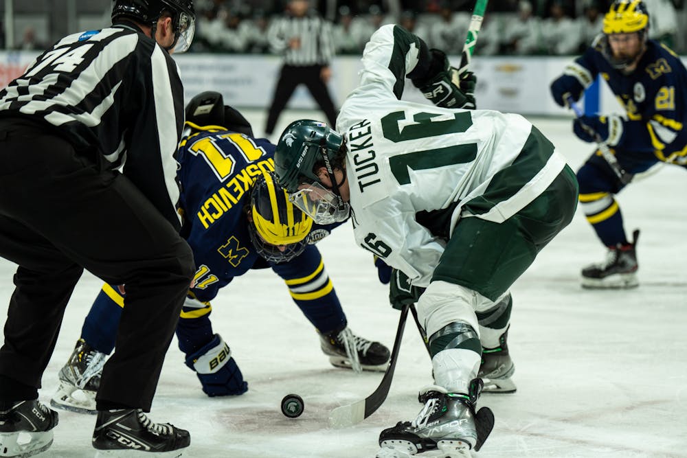<p>Sophomore forward Jesse Tucker (16) wins the puck against University of Michigan sophomore forward Mackie Samoskevich (11) during a game against the University of Michigan at Munn Ice Arena on Dec. 9, 2022. The Spartans defeated the Wolverines 2-1. </p>
