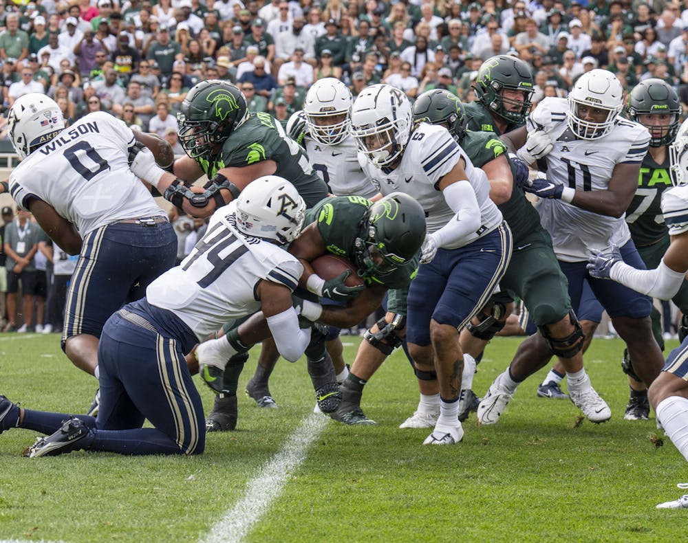 Fifth-year running back Jarek Broussard, 3, is tackled during Michigan State’s game against Akron on Sat., Sept. 10, 2022 at Spartan Stadium. The Spartans earned a decisive victory with a final score of 52, zip. 