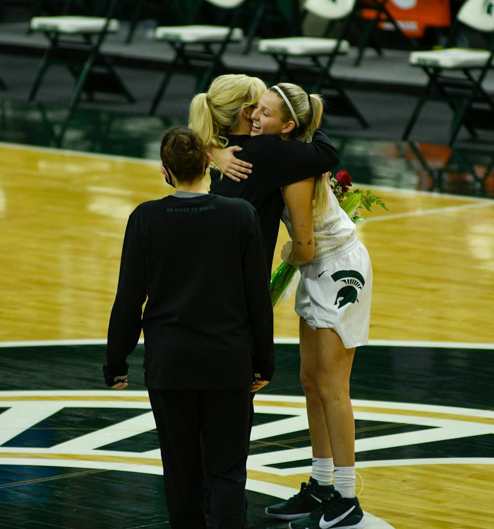 Senior Claire Hendrickson (5) of the Michigan State Spartans hugging the coach of the women's basketball team, Suzy Merchant, at Senior Night after the win against Wisconsin on Saturday, Mar. 6, 2021.