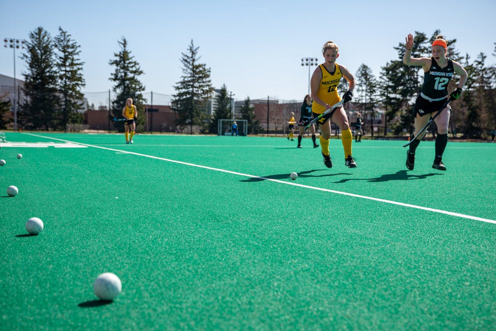 MSU junior Isa Van Der Weij, right, and Michigan senior Kayla Reed, left, chase a ball out of bounds a game on Ralph Young Field on April 2, 2021.