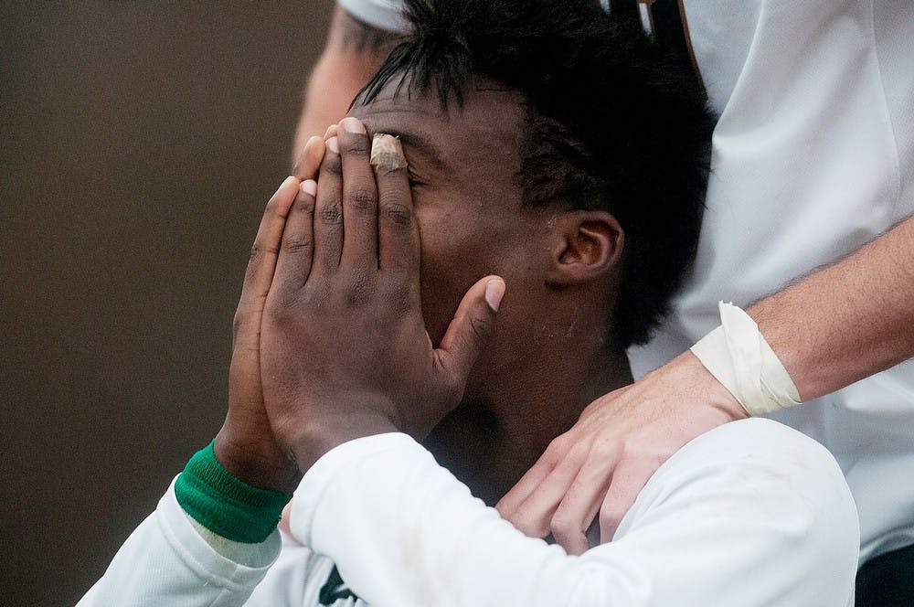 <p>Senior midfielder Fatai Alashe reacts to the team's advancement after scoring the winning penalty kick on Nov. 30, 2014, at DeMartin Stadium at Old College Field. The Spartans tied the Huskies, 2-2, with penalty kicks, 4-3. Aerika Williams/The State News </p>