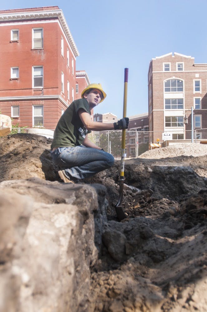 Katy Meyers, campus archeologist and graduate student digs at the site of the foundation of an old boiler room Tuesday, July 10, 2012 behind Morrill Hall.  Construction workers came across the structure last week while working on campus. Adam Toolin/The State News