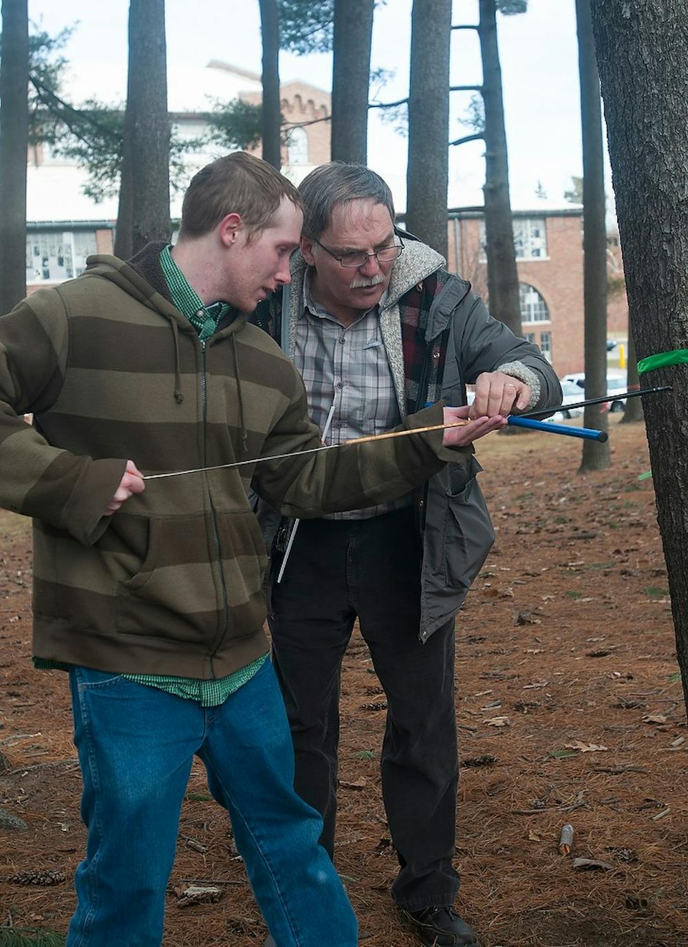 <p>Plant biology professor Frank Telewski and plant biology senior Caleb Adgate pull out the cores of trees to check their health and growth March 19, 2015, in the forests between Munn Ice Arena and Demonstration Hall. Adgate has been working on the undergraduate research since January 2015. Hannah Levy/The State News</p>