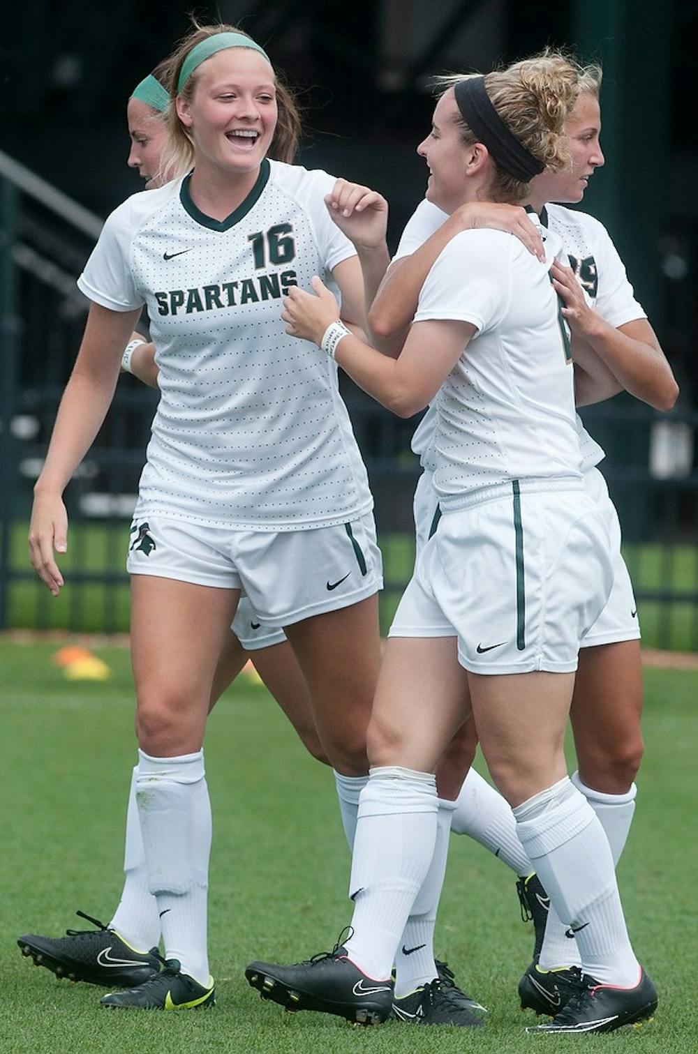 <p>Junior forward Allyson Krause celebrates with teammates sophomore defender Jessica Kjellstrom, 16, and freshman midfielder Morgan McKerchie, 29, after scoring a goal during the game against Eastern Michigan on Aug. 29, 2014, at DeMartin Stadium at Old College Field. The Spartans defeated the Eagles, 3-0. Aerika Williams/The State News</p>