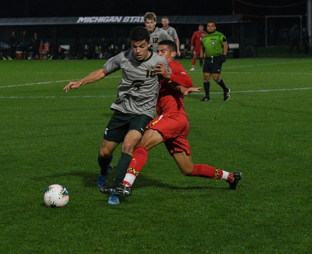 <p>Then-junior midfielder Michael Miller (18) and Maryland then-freshman midfielder Justin Harris (20) fight for the ball during the game against the Terrapins at DeMartin Stadium on Oct. 11, 2019. The Spartans tied the Terrapins, 1-1.</p>