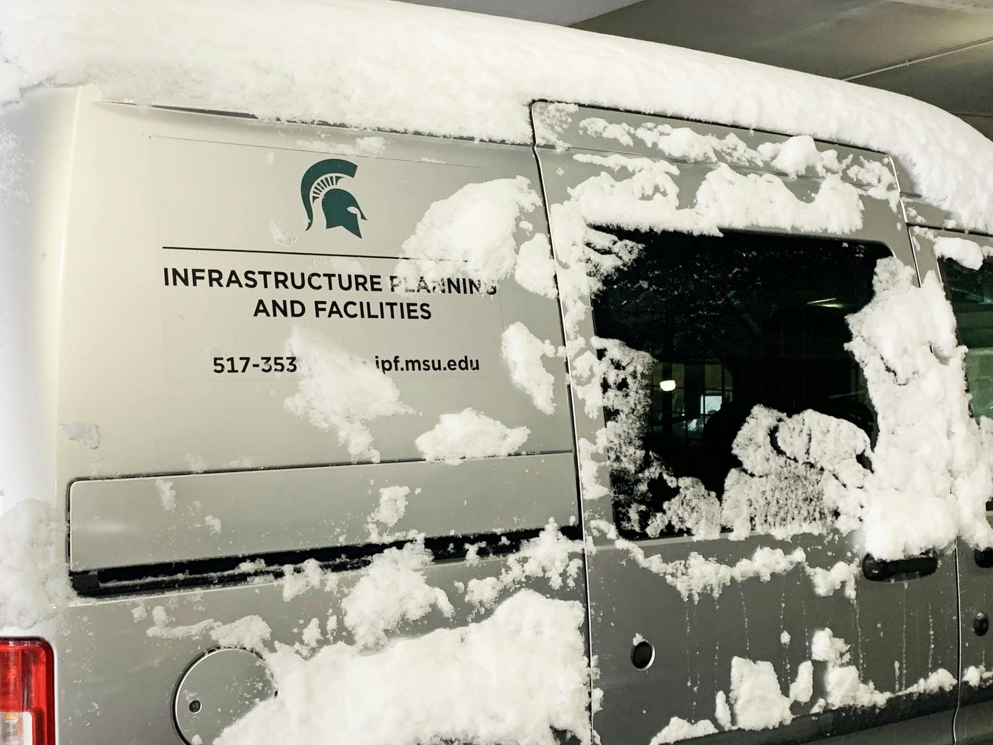 A snow-covered Michigan State Infrastructure Planning and Facilities van. Shot on Feb. 2, 2022. 