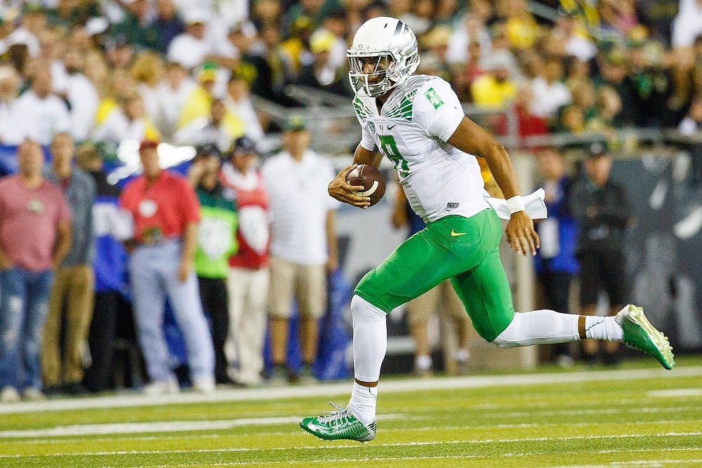 <p>Oregon quarterback Marcus Mariota runs the ball down the field during the game against the South Dakota Coyotes at Autzen Stadium in Eugene, Ore. on Aug. 30, 2014. Photo courtesy of Taylor Wilder/Emerald</p>