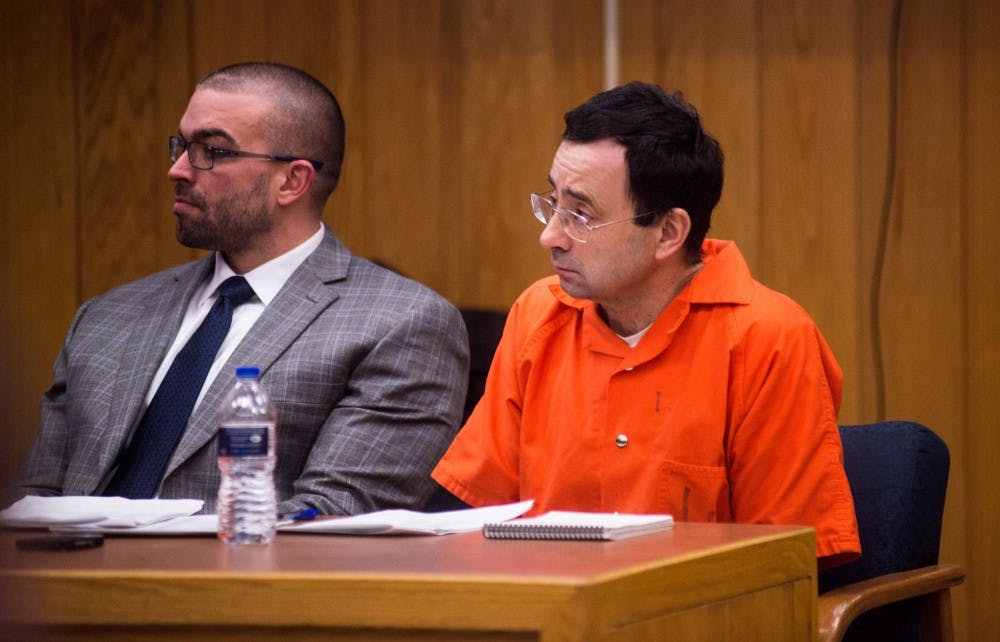 Larry Nassar's defense attorney Matt Newburg and Nassar listen to a victim impact statement on the second day of sentencing for Larry Nassar on Feb. 2, 2018, in the Eaton County courtroom. Nassar faces three counts of criminal sexual conduct in Eaton. (Annie Barker | State News) 