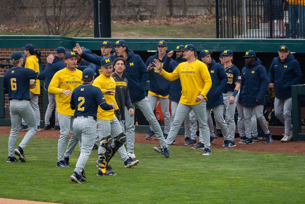 Michigan teammates clap and high-five after a strong defensive play during Michigan’s game against Michigan State at Jeff Ishbia Field at McLane Stadium in East Lansing, Mich., on Friday, April 10, 2026.