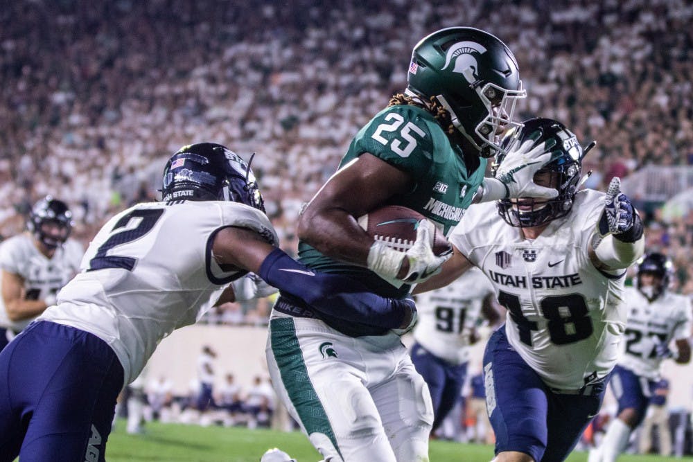 Junior wide receiver Darrell Stewart (25) stiff arms a defender during the game against Utah State on Aug. 31 at Spartan Stadium. The Spartans defeated the Aggies, 38-31.