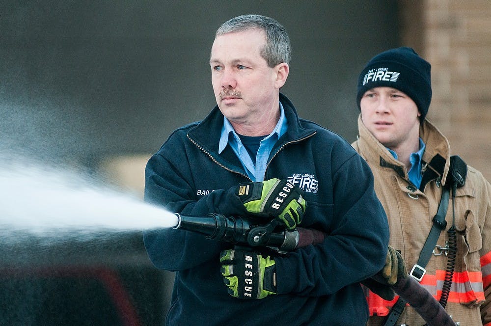 	<p>Firefighter Bill Bailey, left, and firefighter/paramedic Chris Patterson test equipment on Jan. 14, 2013, at the East Lansing Fire Department. The firefighters were having problems with one of the trucks not properly distributing foam. Julia Nagy/The State News</p>
