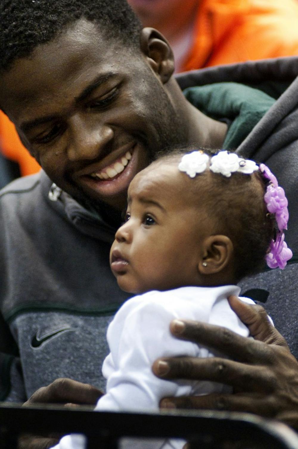Men's basketball senior forward Draymond Green holds the daughter of redshirt senior forward Lykendra Johnson and former men's basketball player Delvon Roe.  The two MSU basketball stars had their daughter, Destinie Roe, 1, in October of last year. Matt Hallowell/The State News