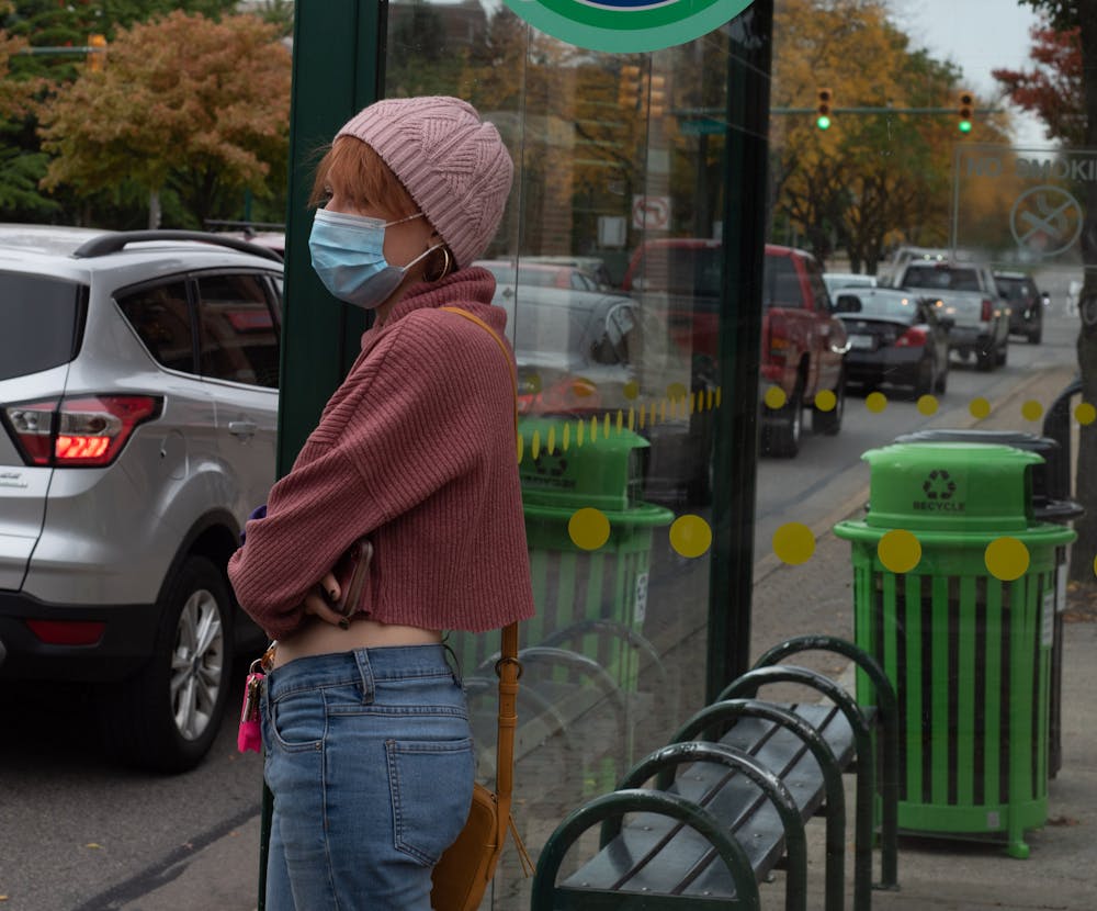 <p>Hailey Pecic wearing her mask while waiting at a CATA bus stop on Wednesday, October 14, 2020. </p>