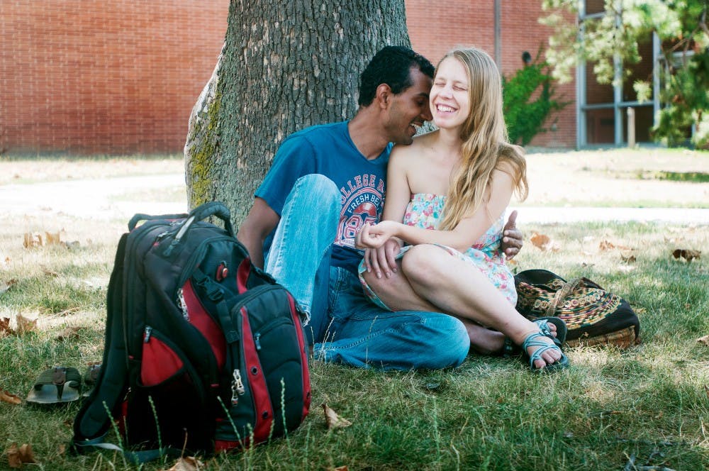 Graduate students Sara Jablonski and Mukesh Ray laugh and talk while sitting under the shade of a tree outside of IM Sports-West on Sunday July 8, 2012 afternoon. Jablonski, from Buffalo, N.Y., and Ray, an international student from India, met at MSU this summer and have been dating for about a month. Samantha Radecki/The State News